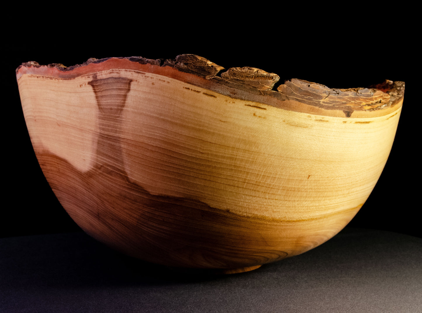 Large bowl with warm grain and bark-on natural edge. This is a family style serving bowl that would make for a stunning centerpiece or other decorative gift.