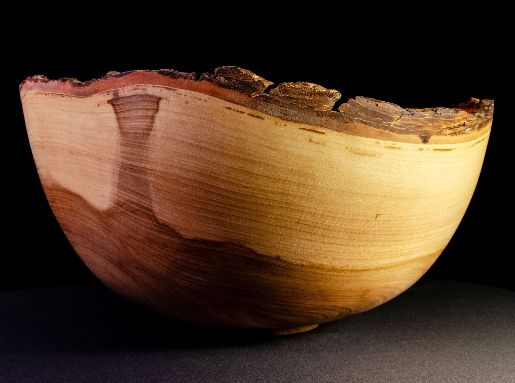 Large bowl with warm grain and bark-on natural edge. This is a family style serving bowl that would make for a stunning centerpiece or other decorative gift.