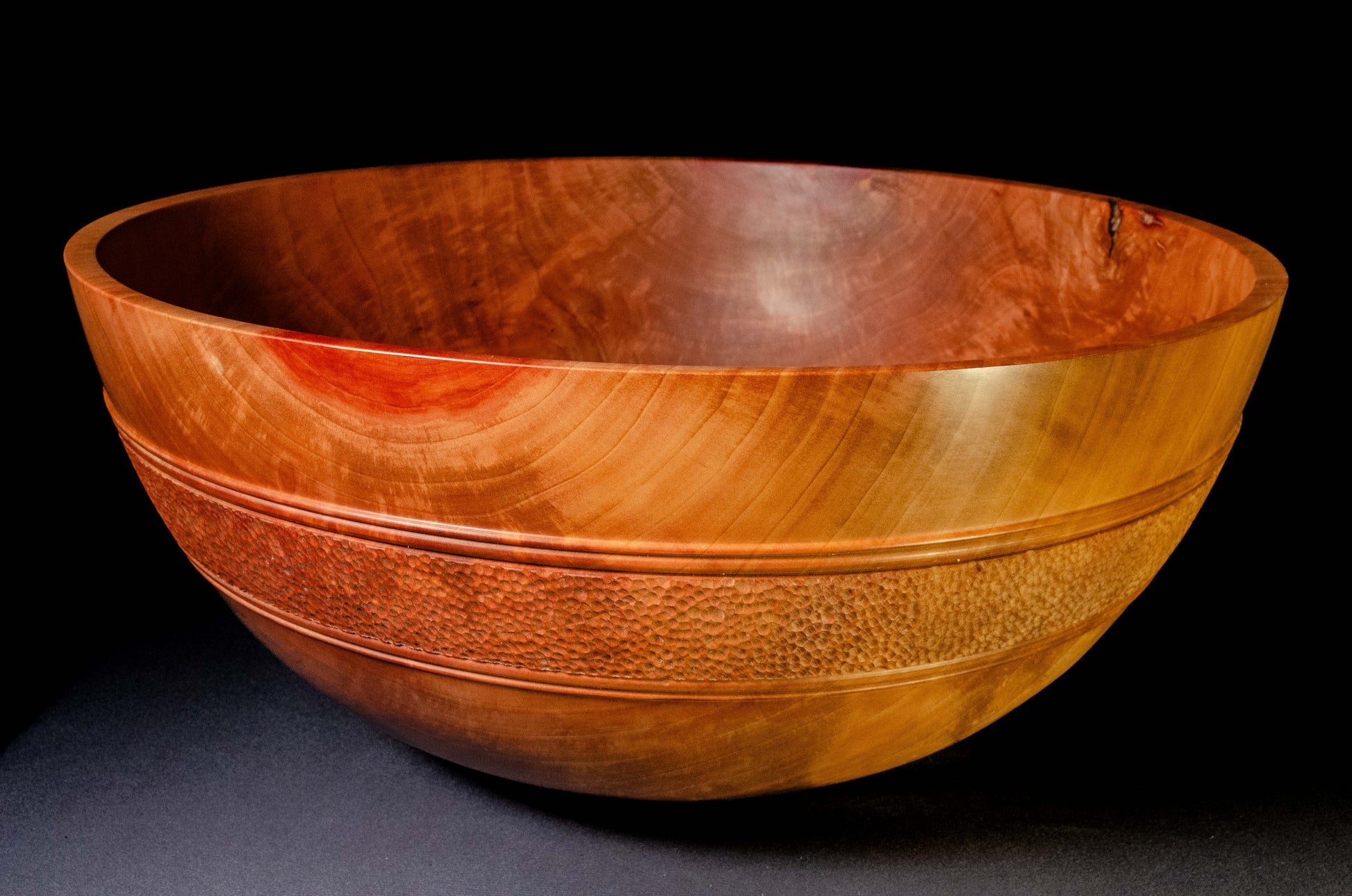 Large bowl of Pear wood with wwell-defined grain patterns. A belt of hand textured stippling encircles the bowl exterior, providing a strong visual balance and focal point. This is an heirloom bowl intended as a special gift.